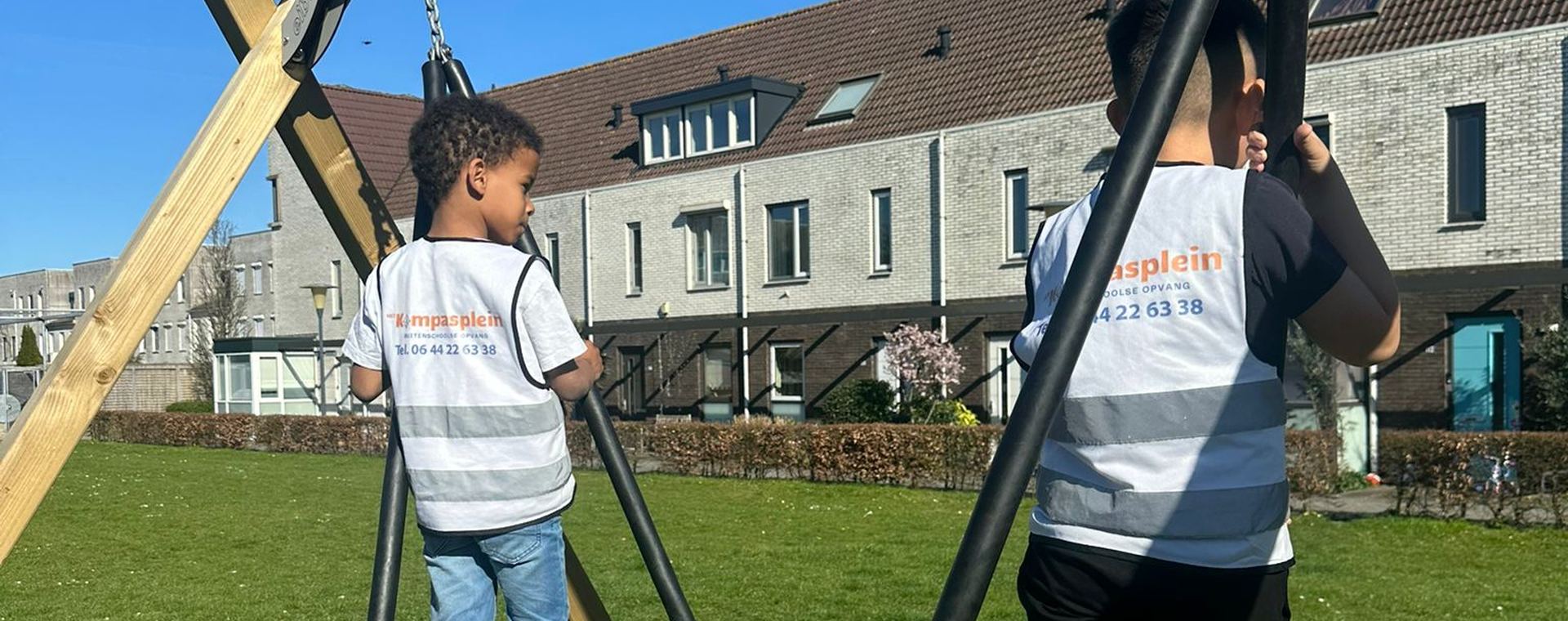 Kinderen spelen op de nestschommel buiten bij BSO Het Kompasplein