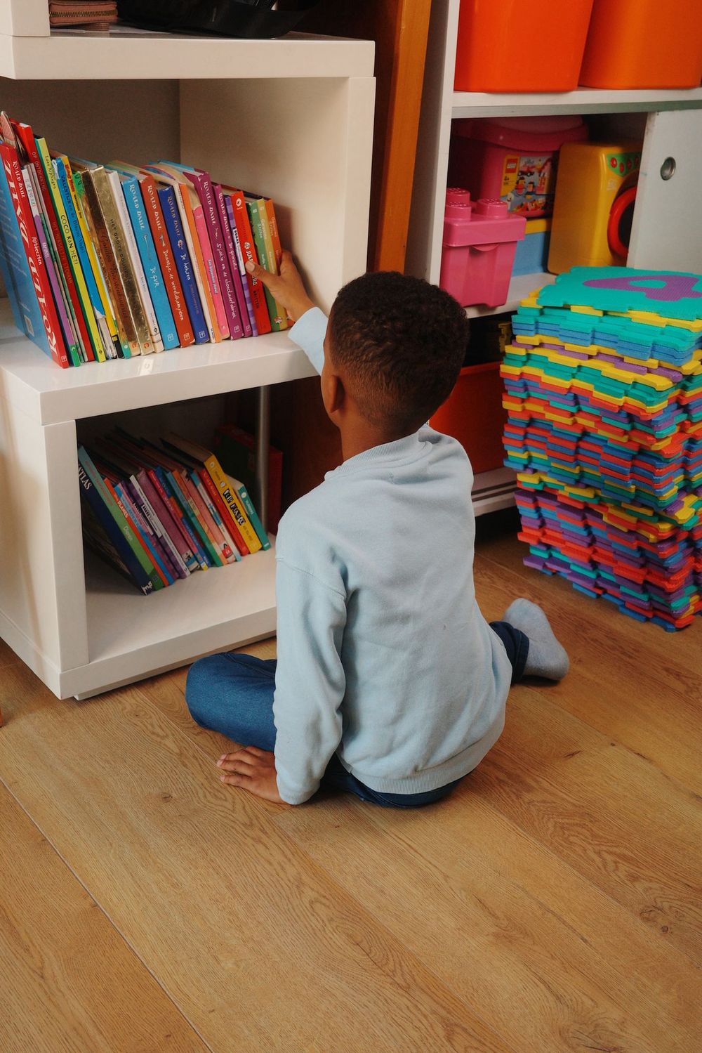 Kind leest een boek in de boekenhoek van de BSO